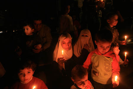 Palestinian children participate in a candle-light demonstration after Gaza plunged into darkness on Nov. 10, 2008. The only power station in Gaza Strip was forced to shut down on Monday due to the Israeli blockade of fuel deliveries, leaving 800,000 people into blackout. (Xinhua Photo)