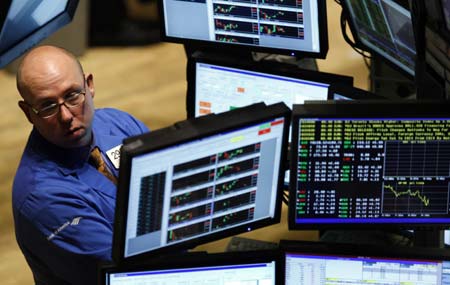 A trader peers out from behind screens as he works on the main trading floor of the New York Stock Exchange early in the trading session, November 10, 2008.