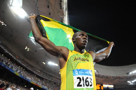 Jamaica's Usain Bolt displays the national flag of Jamaica after taking men's 100m final at the National Stadium, also known as the Bird's Nest, during Beijing 2008 Olympic Games in Beijing, China, Aug. 16, 2008. Usain Bolt claimed the title of the event and broke the world record. [Xinhua] 