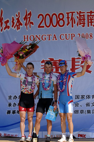 Dmitriy Gruzdev (C) of Kazakhstan waves after he won the leader of the Best Asian Rider, the leader of the individual General classification and the first rider at the prelude competition at 2008 International Road Cycling Race around Hainan Island in Sanya of south China's Hainan Province, Nov. 11, 2008. A total of 127 cyclists from 20 teams took part in the race. [Xinhua]