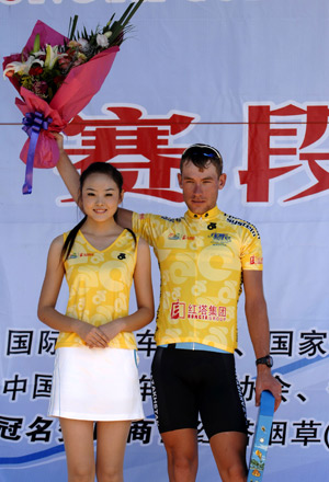 Dmitriy Gruzdev (R) of Kazakhstan waves after he won the leader of the Best Asian Rider, the leader of the individual General classification and the first rider at the prelude competition at 2008 International Road Cycling Race around Hainan Island in Sanya of south China's Hainan Province, Nov. 11, 2008. [Xinhua]