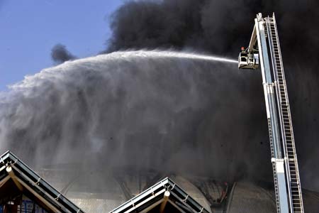 Firefighters try to extinguish fire at a stadium under construction in Jinan, capital of east China's Shandong Province, on Nov. 11, 2008. [Xinhua]