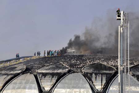 Firefighters try to extinguish fire at a stadium under construction in Jinan, capital of east China's Shandong Province, on Nov. 11, 2008. [Xinhua] 