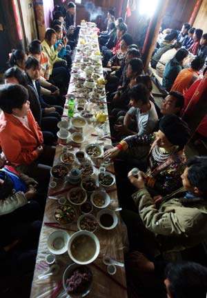 People attend the long-table wedding feast on the ethical wedding of Bride Zhao Minlian and bridegroom Li Youqing in Tonglian Township of Yao ethnic group in Rongshui County, southwest China's Guangxi Zhuang Autonomous Region, Nov. 9, 2008. 