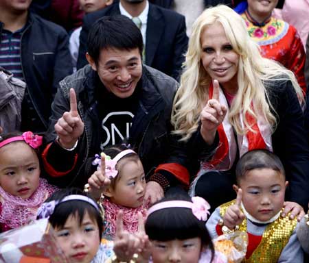 Italian designer Donatella Versace (back, R) and Chinese actor Jet Li pose for photo with quake-affected children at the Versace-One Foundation children center at Sanjiang, Wenchuan county, southwest China's Sichuan Province, Nov. 11, 2008. 