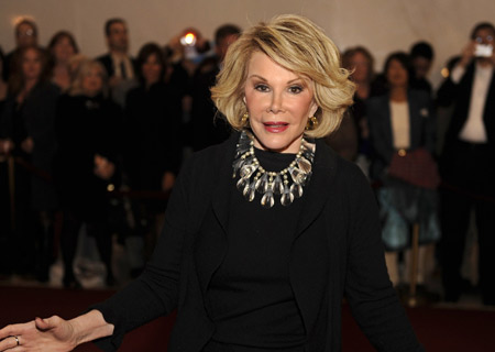 Comedian Joan Rivers poses for photographers as she arrives for the Kennedy Center's Mark Twain Prize for American Humor Gala 