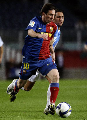 Barcelona's Lionel Messi (L) dribbles next to Benidorm's Dani during their Spanish King's Cup soccer match at the Nou Camp stadium in Barcelona November 12, 2008. [Xinhua/Reuters]