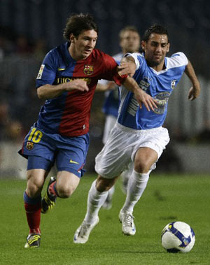 Barcelona's Lionel Messi (L) challenges Benidorm CD's Dani during their Spanish King's Cup soccer match at the Nou Camp stadium in Barcelona November 12, 2008. [Xinhua/Reuters]