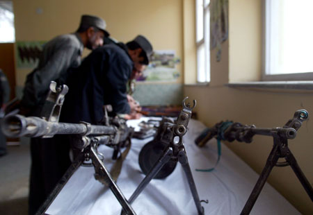 An Afghan police officer checks weapons seized from criminal gangs, in Kabul, capital of Afghanistan, Nov. 12, 2008. 