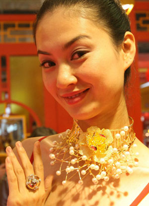 A model shows gold ornaments at the China International Jewellery Fair held in Beijing, capital of China, Nov. 11, 2008. 