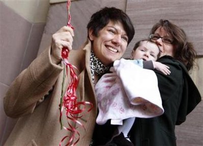 Peg Oliveira (L) and her partner Jennifer Vickery (R) celebrate their marriage holding their daughter Willow shortly after the two were married outside New Haven City Hall in New Haven, Connecticut, November 12, 2008. 