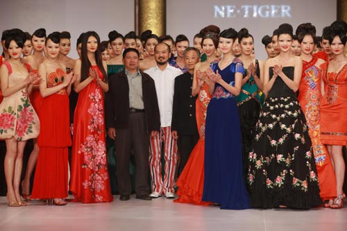 Zhang Zhifeng(middle), the inspiration behind the company and its Chief Designer, presented his 2009 Spring / Summer Hua Fu collection.[China.org.cn]