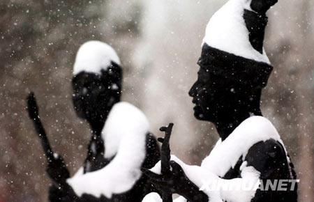 Heavy snow hit Aletai, northwest China's Xinjiang Uygur Autonomous Region on November 13, 2008. In the picture are two statues on the street of Aletai city.