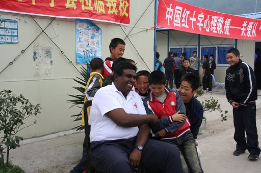 Dr Jeya Kulasingam, Health and Psychosocial Support Delegate of the IFRC chats to children at the Sunshine in Your Heart psychosocial project organized by the Red Cross Society of China in Yinghua Middle School, Yinghua Township, Shifang City (Sichuan Province) on 10th and 11th November 2008. [Photo: Francis Markus/IFRC]