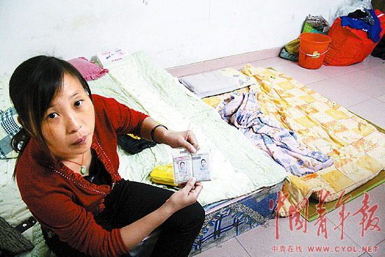 He Chunxia, a former employee of Junling Toy Factory shows her employment card in her rented house in Dongguan, Guangdong Province.