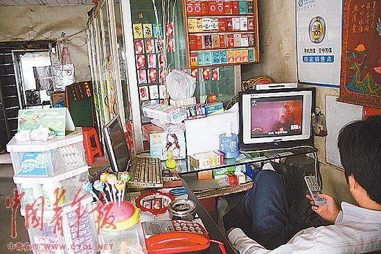 A shop providing phone services have no customers after Hejun Toy Factory was closed in Dongguan, Guangdong Province. The shopkeeper is seen watching TV to kill time.