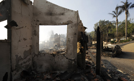 The remains of a urned home is seen as firefighters work to contain a wildfire which has destroyed over 100 homes in the Montecito area of Santa Barbara County, California November 14, 2008.