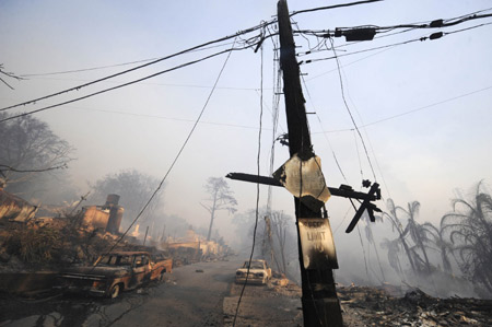 A burnt utility pole stands along a heavily damaged street in the Montecito area of Santa Barbara County, California November 14, 2008.