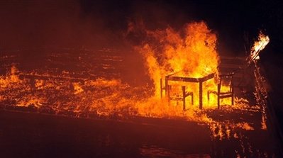 The pool deck of a mansion burns during a wildfire, Friday, Nov. 14, 2008, in Santa Barbara, Calif. An official in Santa Barbara County, says the fire has destroyed about 70 homes in the upscale community of Montecito. 