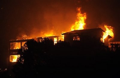 A mansion burns during a wildfire, Friday, Nov. 14, 2008, in Santa Barbara, Calif. An official in Santa Barbara County, says the fire has destroyed about 70 homes in the upscale community of Montecito.