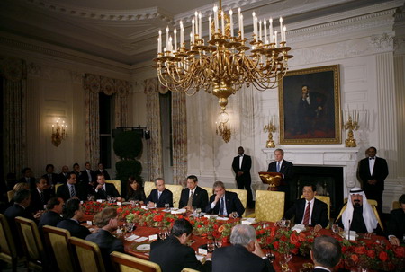 US President George W. Bush (standing, C) addresses leaders gathered in the State Dining Room before the G20 Summit on Financial Markets and the World Economy in Washington November 14, 2008. 