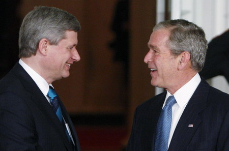 US President George W. Bush (R) talks with Canada's Prime Minister Stephen Harper upon arrival at the North Portico of the White House before a dinner for the participants in the G20 Summit on Financial Markets and the World Economy in Washington, November 14, 2008. 