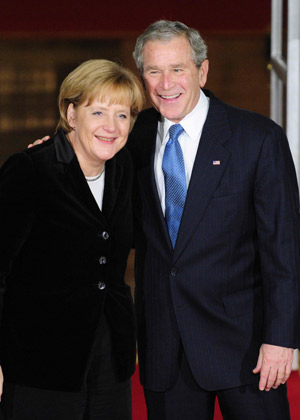 U.S. President George W. Bush (R) poses with German Chancellor Angela Merkel upon her arrival at the North Portico of the White House before a dinner for the participants in the Summit on Financial Markets and the World Economy in Washington, November 14, 2008. 