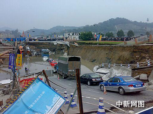 Several vehicles are trapped in a crater after a section of road collapsed into the tunnel in Hangzhou, capital of Zhejiang Province, on Saturday, November 15, 2008. [Photo: chinanews.com]