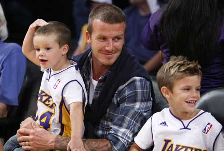 Soccer star David Beckham (C) and his sons Romeo (R) and Cruz watch the Los Angeles Lakers play the Detroit Pistons in their NBA basketball game in Los Angeles November 14, 2008.