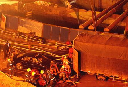 Rescuers work at the collapsed road where a subway tunnel was under construction in Hangzhou, capital of east China's Zhejiang Province, Nov. 15, 2008. 