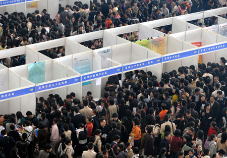 Job seekers crowd into an employer's stall at the job fair for medicine graduates in Nanning, capital of east China's Jiangsu Province, Nov. 15, 2008. A job fair kicked off here on Saturday with over 5,000 jobs vacancies provided by more than 100 enterprises. 