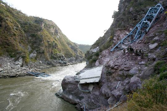 Indian soldiers hunt for accident survivors around the collapsed bridge. The bridge under construction over an Himalayan river in Indian-controlled Kashmir collapsed Sunday, killing at least four workers and leaving 19 others missing and feared dead, local police said.