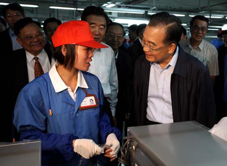 Chinese Premier Wen Jiabao (R) talks with an assembly line worker during his visit to a medium-sized enterprise in Foshan of south China's Guangdong Province, November 15, 2008. 