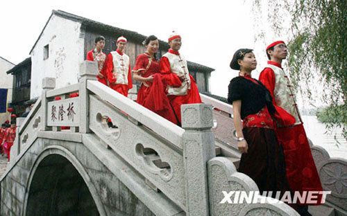 Keeping with tradition, 12 couples walk over three bridges that will bring them luck, happiness and prosperity during a wedding ceremony at Shajiabang water village in east China's Jiangsu Province on November 16, 2008. [Photo: Xinhua]