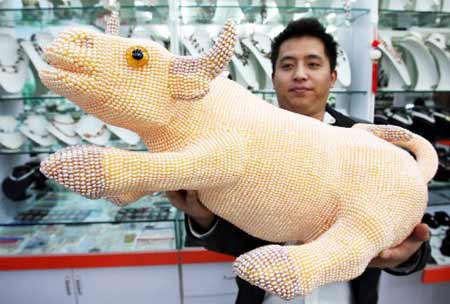 Photo taken on Nov. 17, 2008 shows a 85-cm-long, 55-cm-high ox figurine made of 130,000 pearls at a store of Suzhou, east China&apos;s Jiangsu Province.