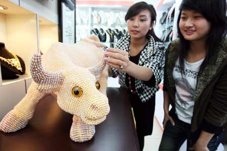 Photo taken on Nov. 17, 2008 shows a 85-cm-long, 55-cm-high ox figurine made of 130,000 pearls at a store of Suzhou, east China&apos;s Jiangsu Province.