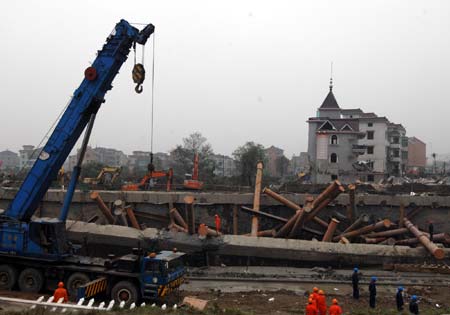 Scrapers work at the site of the subway tunnel collapse in Hangzhou, east China's Zhejiang Province, on Nov. 17, 2008. The incident happened at 3:20 p.m. when a 75-m section of a tunnel under construction collapsed in Xiaoshan District, trapping about 50 workers and 11 vehicles. The cause of the collapse is being investigated.