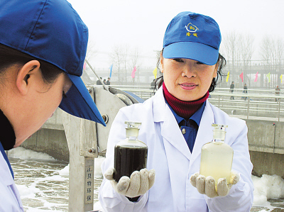 A technical worker shows the water before and after treatment. The Hailin Sewage Treatment Plant, the first county-level sewage treatment plant in northeast China's Heilongjiang Province with an investment of 130 million yuan, was put into operation recently after 16-month construction.