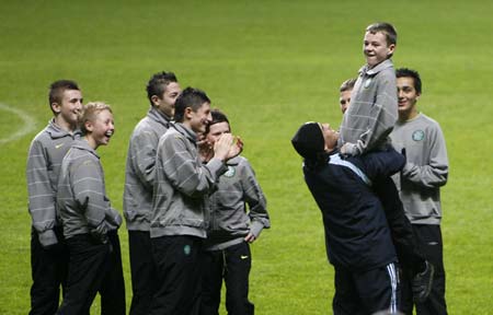 Argentina's soccer team head coach Diego Maradona lifts Celtic Park stadium ball boy Adam Brown after he found a necklace Maradona lost during a training session at Celtic Park stadium in Glasgow, Scotland on November 17, 2008. Argentina play Scotland in an international friendly soccer match at Hampden Park stadium on Wednesday.