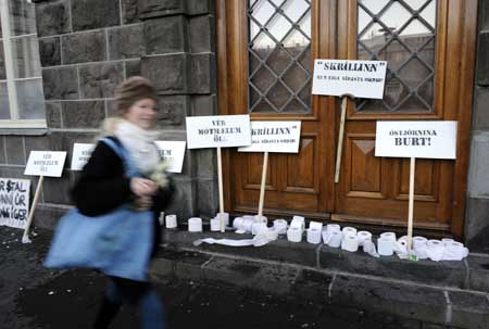 A girl walks by posters placed by protestors against the government, in front of the parliament office in Reykjavik, capital of Iceland, Nov. 15, 2008. 