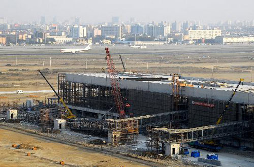 Terminal 2 of Shanghai Hongqiao Airport is still busy under construction on Tuesday, November 18, 2008. The new terminal finished structural roof-sealing on Tuesday and started interior decorating. It is planned to put into operations in March 2010 in time for the World Expo. [Photo: Xinhua]