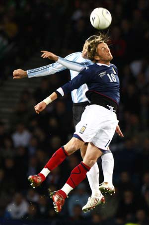 Scotland's Lee Miller (R) clashes with Argentina's Martin Demichelis during their international friendly soccer match at Hampden Park stadium in Glasgow, Scotland November 19, 2008. [Xinhua/Reuters]