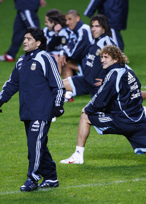 Argentina's soccer team head coach Diego Maradona walks past his players during a training session at Celtic Park stadium in Glasgow, Scotland on Nov. 17, 2008. [Xinhua/Reuters]