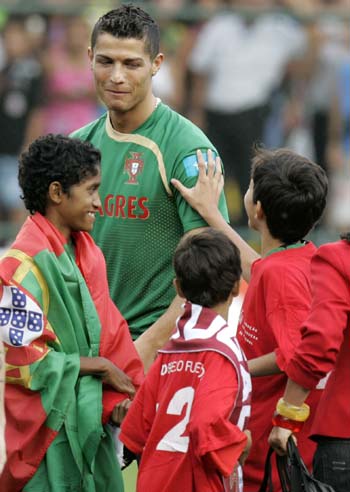 Cristiano Ronaldo of Portugal smiles to fans during a training session in Brasilia November 18, 2008. [Agencies]