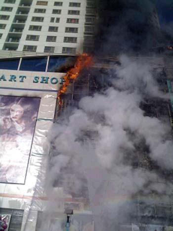 Smoke rises from a fire in a shopping mall called New-Mart Plaza in downtown Qiqihar, Northeast China's Heilongjiang Province, November 19, 2008. 