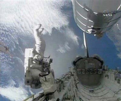 In this image from NASA TV, astronaut Stephen Bowen maneuvers down the cargo bay of the space shuttle Endeavour as he prepares to assist astronaut Heidemarie Stefanyshyn-Piper in placing an empty nitrogen tank into the shuttle's cargo bay, November 18, 2008. 