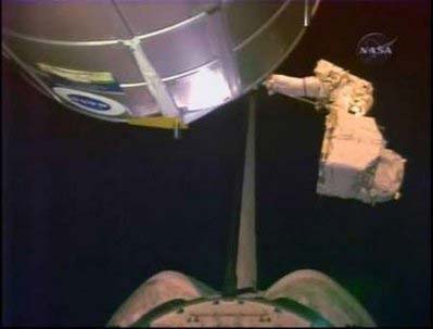 Heidemarie Stefanyshyn-Piper on the end of the robot arm as she moves a nitrogen tank assembly to the Space Shuttle Endeavour's cargo bay during orbital night in this image from NASA TV November 18, 2008. 