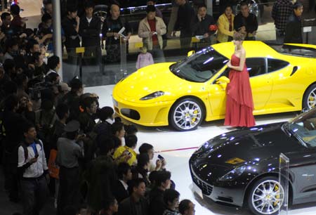 A model stands next to a car at the 6th Guangzhou International Automobile Exhibition in Guangzhou, South China's Guangdong Province, November 18, 2008. 