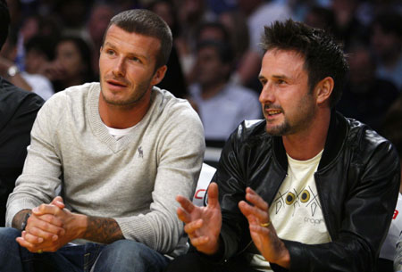 Soccer star David Beckham (L) chats with actor David Arquette as they watch the Los Angeles Lakers play the Chicago Bulls in their NBA basketball game in Los Angeles November 18, 2008.