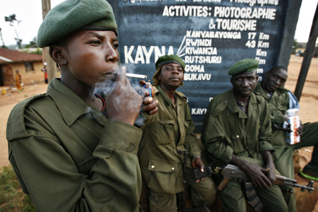 A government soldier smokes after a day of fighting in the looted village of Kayna in eastern Congo, Nov.18, 2008. 